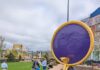 Arts Landing Opens in Pittsburgh as a New Downtown “Backyard” A large statue of a man with a snake and purple circle above his head sits in Arts Landing.