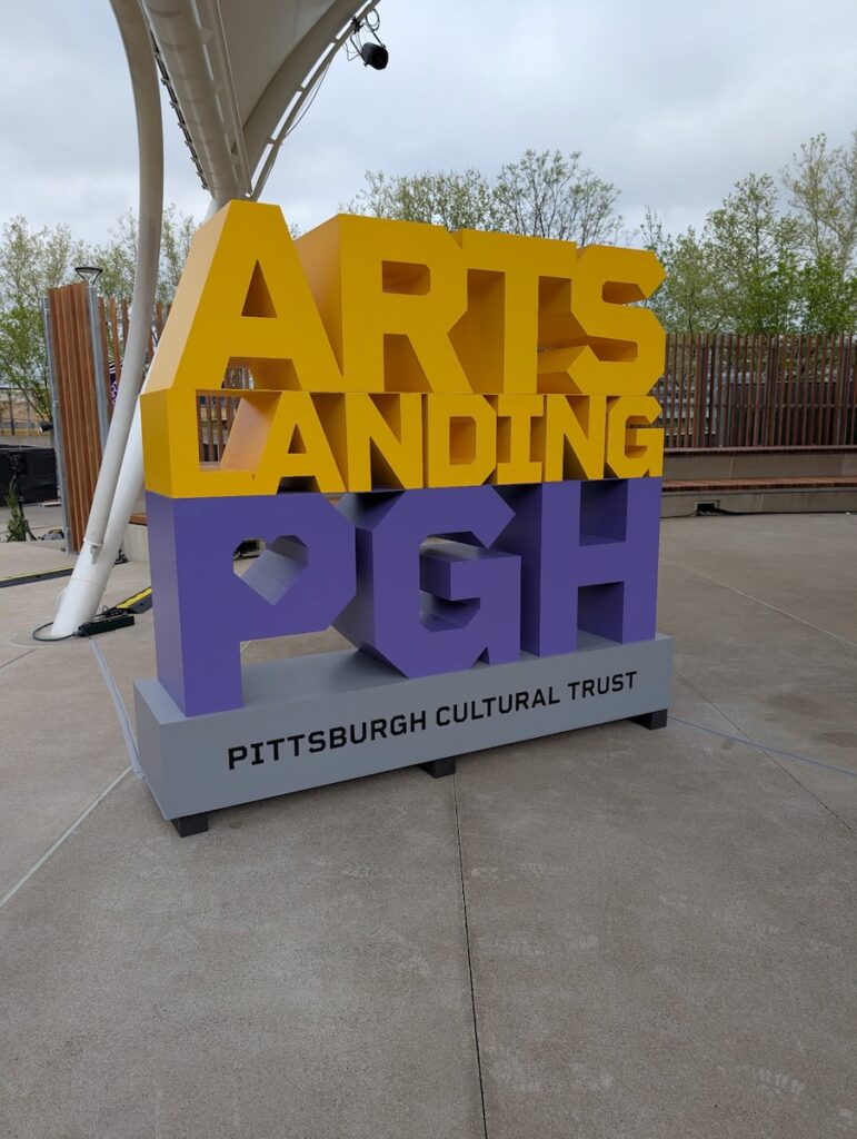 The Arts Landing PGH sign in bold yellow and purple letters.