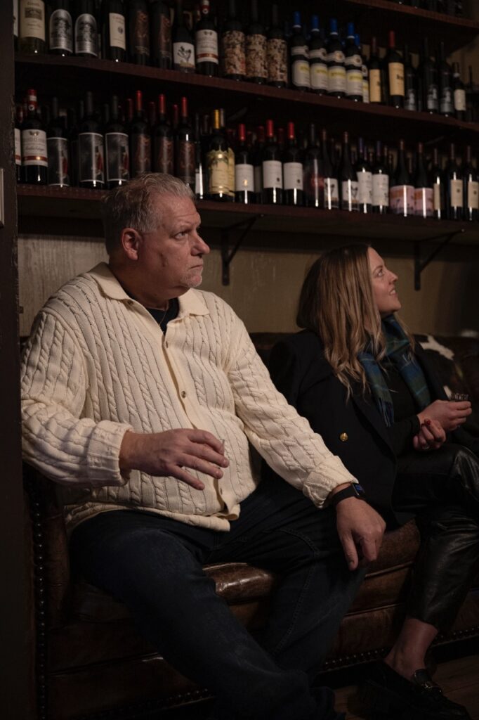 A man and a woman sit holding samples of scotch in their hands.