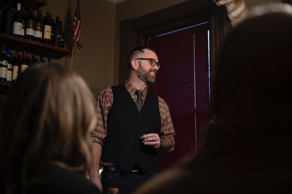 A man in a black vest and plaid shirt.