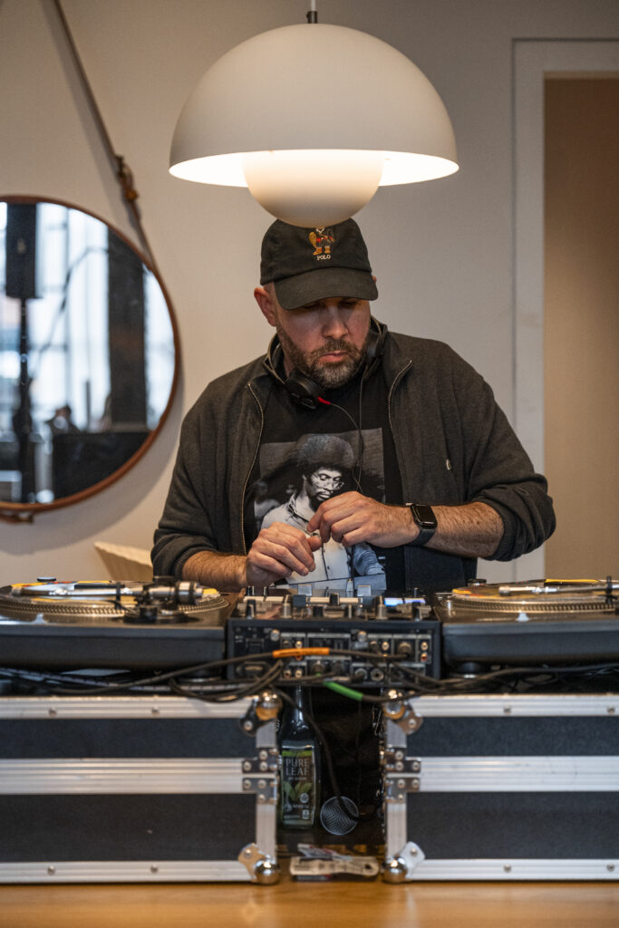 A DJ looks down at his turntable.