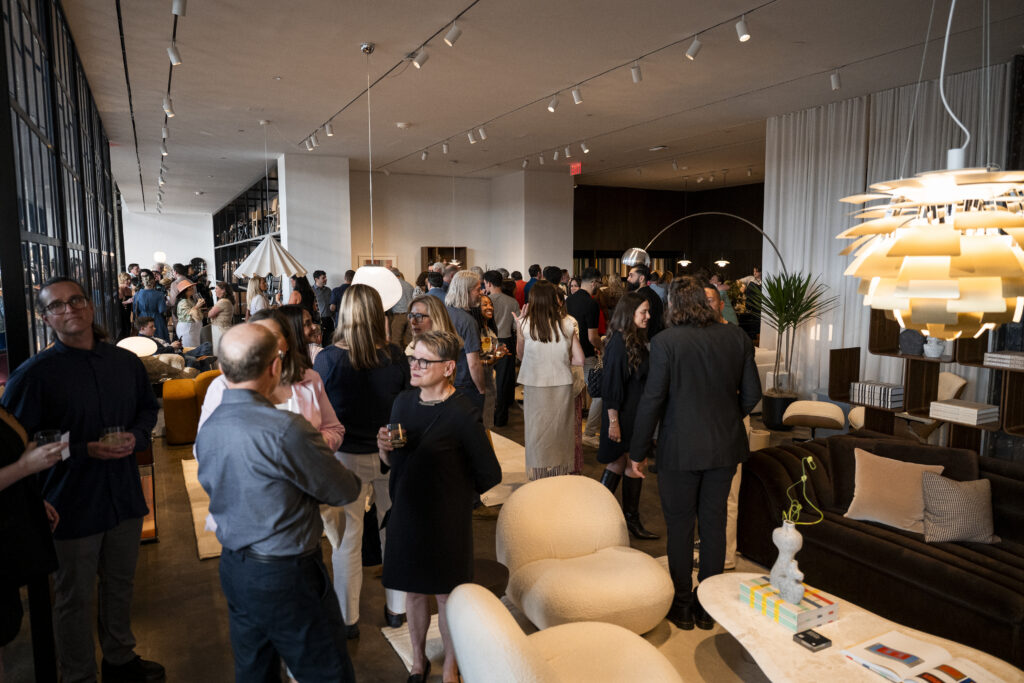 A crowd of people gather and talk in the Design Within Reach large showroom.