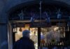Florence Travel Guide: The Sunset Food Tour on the Other Side of the Arno A man in a jacket walks into a small shop front.
