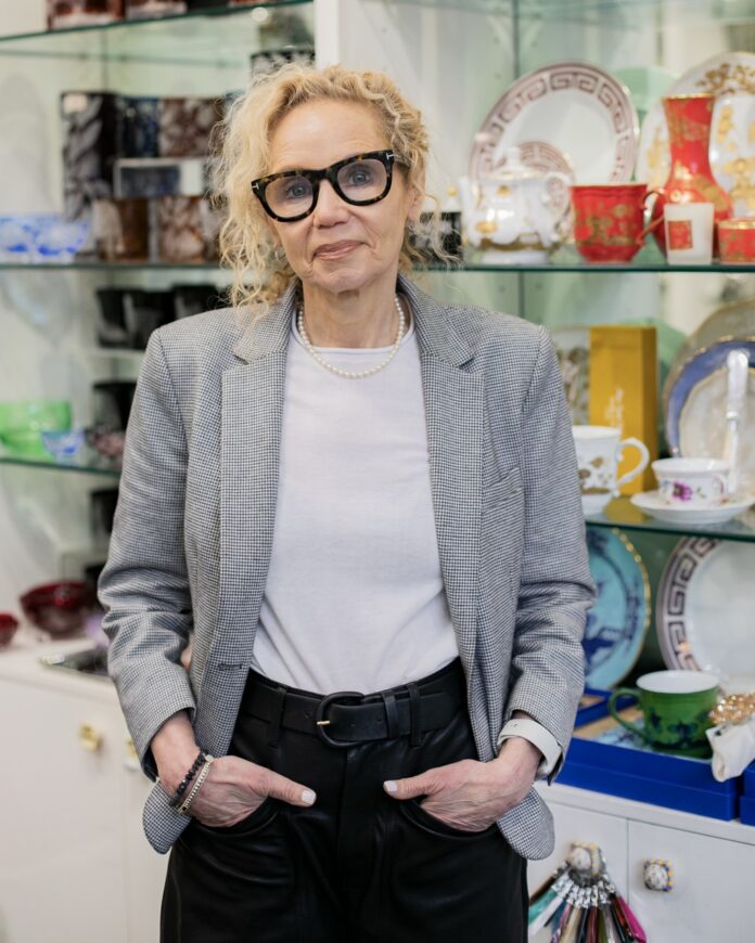 Ilene Levy's Shops Deliver Craft Home Goods and Luxury Fashion in Pittsburgh Ilene Levy stands in front of shelves of dinnerware and glass at glassworks in Pittsburgh.