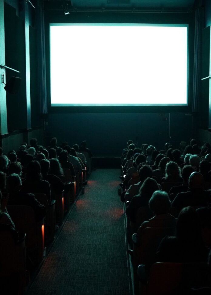 A film screen in front of an audience in a theatre.