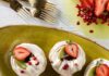 6 Refreshing Kiwi Dessert Recipes for Spring and Summer Six round swirls of pavlova with kiwi jam in the center, a piping of orange zest whipped cream, and a half strawberry on top.