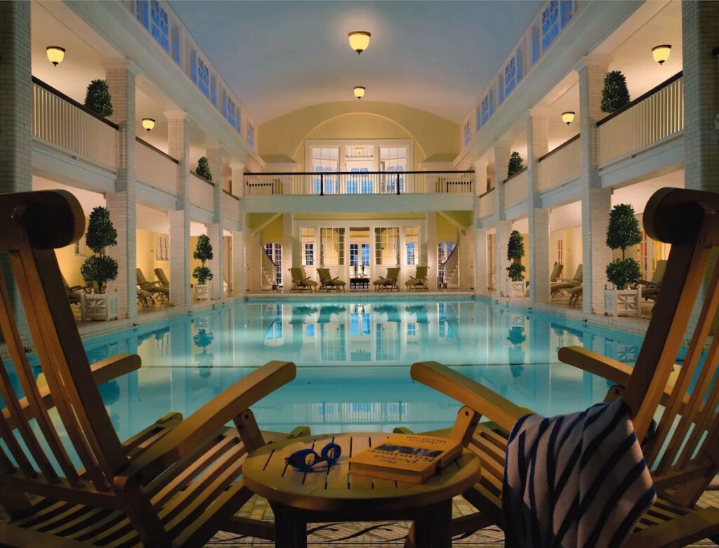 Two chairs inside a large pool room in a hotel.