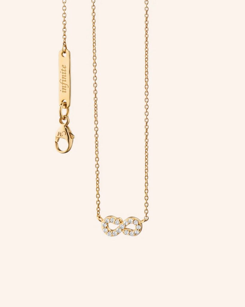 A gold necklace with an infinity sign at the bottom of the chain.