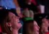 Sean Collier’s Movie Events Guide for April and May in Pittsburgh A woman at the movies laughs as she watches the screen and eats popcorn.