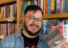 Pittsburgh’s Best Literary Events for Bookworms May 2026 A bookkeeper at White Whale in Pittsburgh holds a stack of books in one hand and two other books in his other hand.