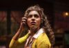 Memories of the Pittsburgh Public Theater On Its 50th Anniversary A woman in a yellow sweater holds a radio up to her ear, a newspaper under her arm.