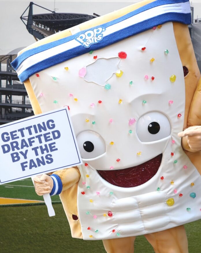 Giant Edible Pop-Tart Mascot to Be ‘Sacrificed’ at NFL Draft A giant pop-tart mascot with a headband on and a sign about getting drafted by the fans for the NFL Draft.