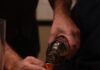 Thoughts on Scotch From Aficionado Gordon Valle Gordon Valle pours Scotch from a bottle into a small tasting cup.