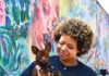 Pittsburgh Events: Your Guide to April 20-26 A woman with curly hair holds a small dog against her blue Pittsburgh animal rescue shirt.