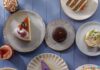 Where to Get the Best Cakes for Any Occasion in Pittsburgh Plates full of different sices of cake like strawberry, carrot, matcha, confetti sprinkles, and other types on a purple picnic table.