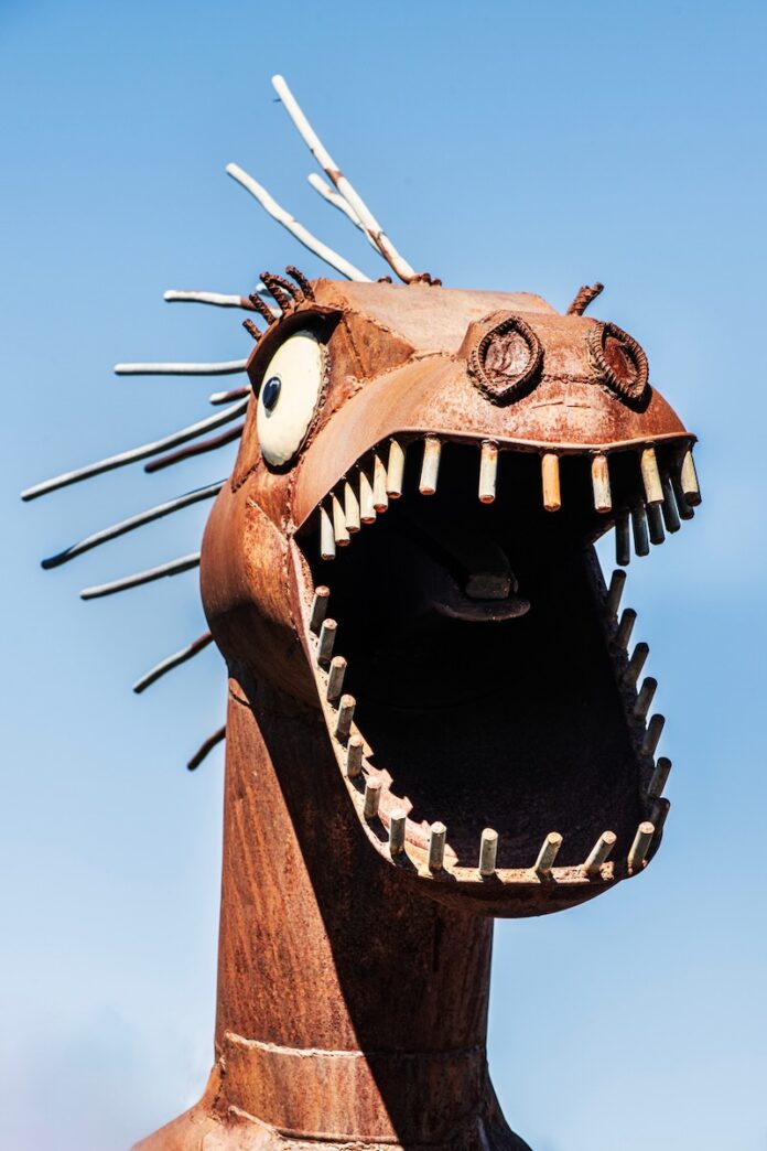 A dinosaur sculpture made out of scrap metal.