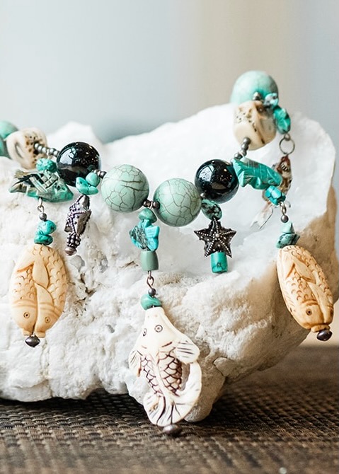 A bead bracelet with seashell charms on a crystal rock.