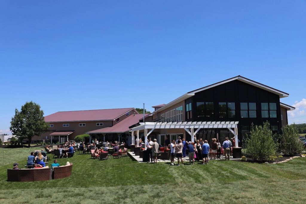 Outside at a Lake Erie vineyard with people gathering on the grass.