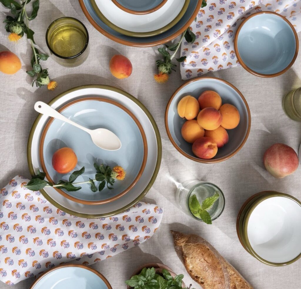 A table of baby blue plates with peaches on them.