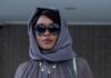 Collier’s Cuts: Serving Revenge in ‘Is God Is’ A woman in a sheet long sleeve shirt and scarf around her head with sunglasses on.