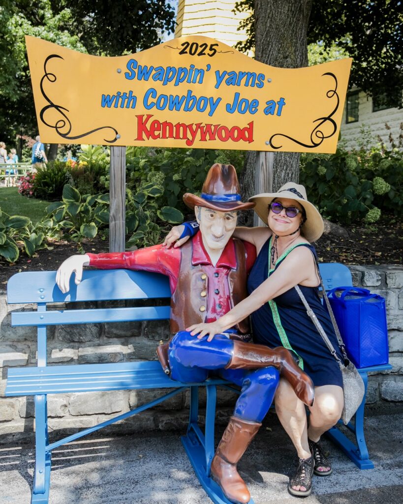 A woman wraps her arm around a cowboy statue.