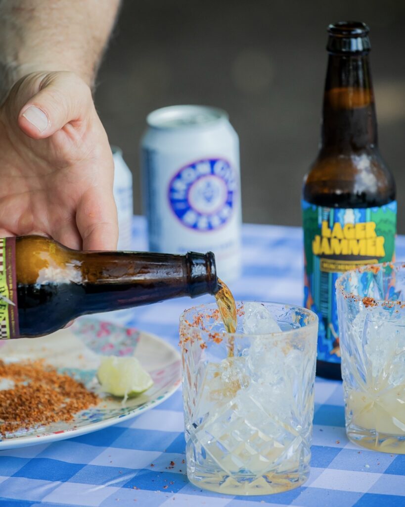 A person pours beer into a drinking glass.
