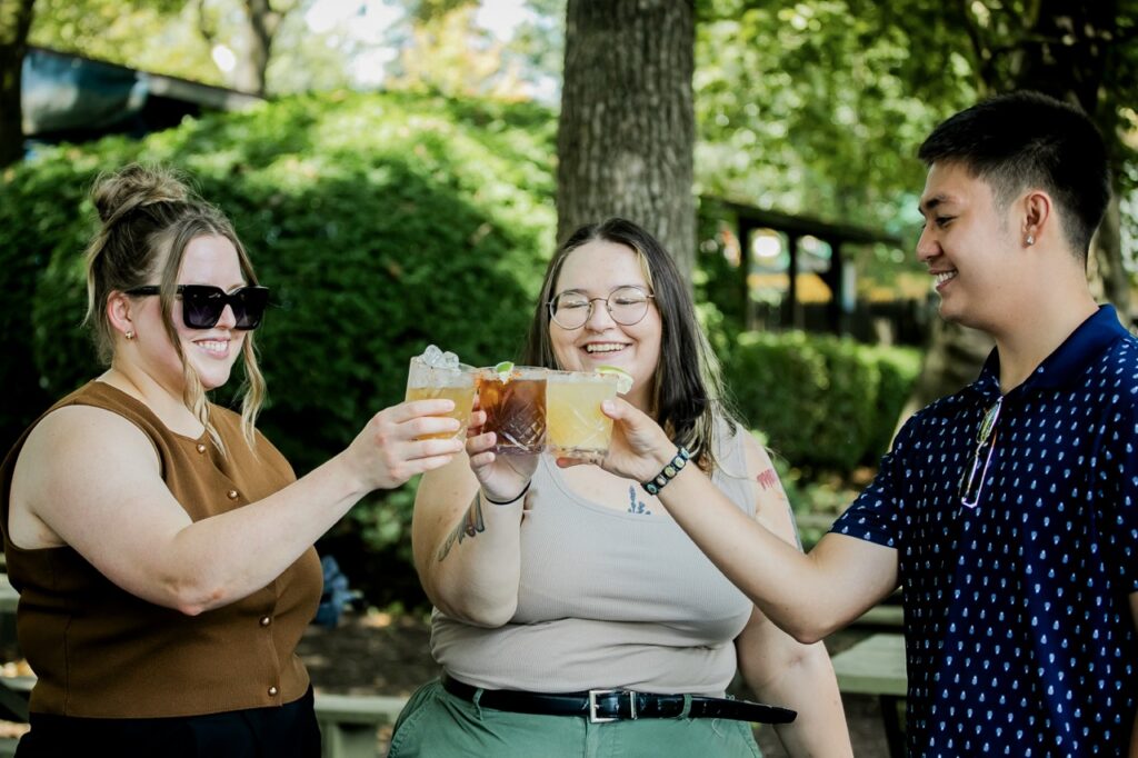 Three people cheers beers.