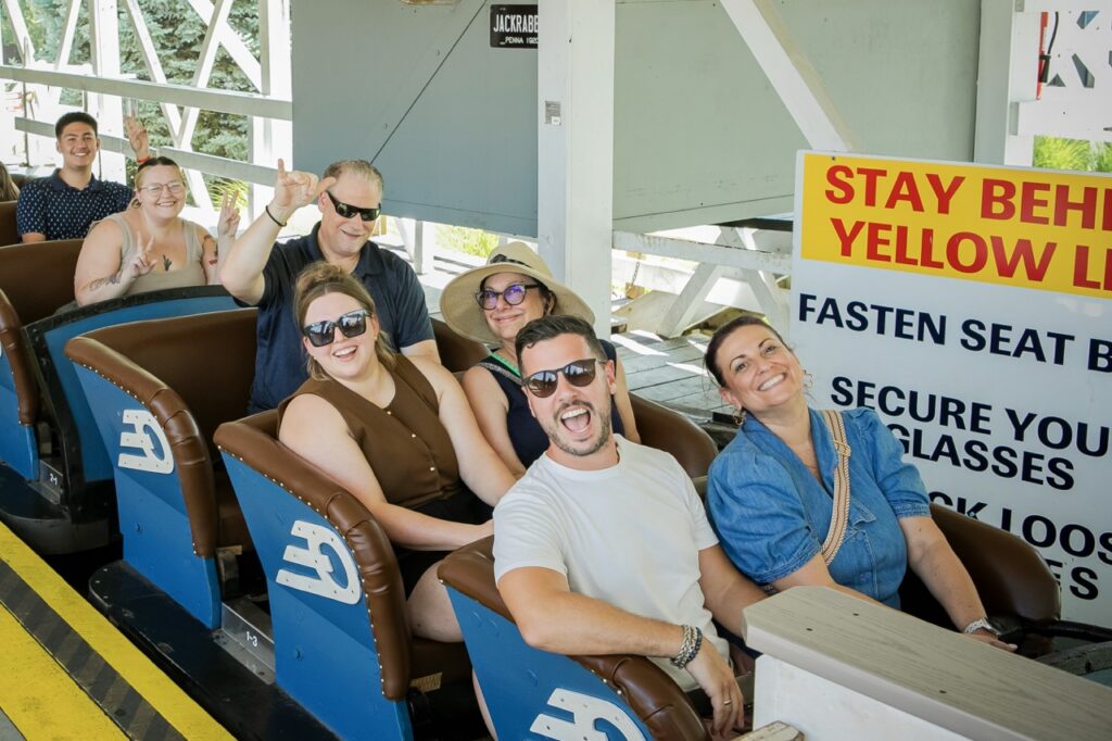 People on a roller coaster in blue carts.