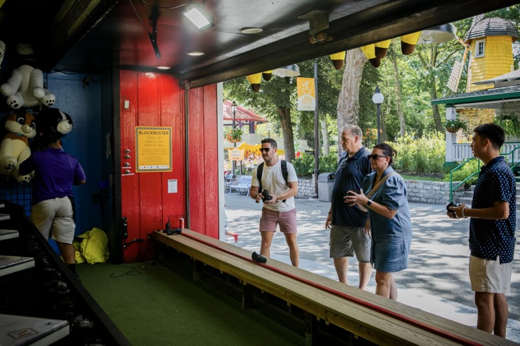 Four people get ready to throw bean bags at a game.