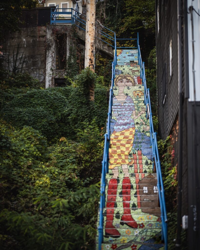 A long staircase with painting on them that make a photo through perspectives.