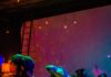 Top Dance Shows Coming to Pittsburgh in 2026 Two people dance on stage in multi-color lights, bending backwards.