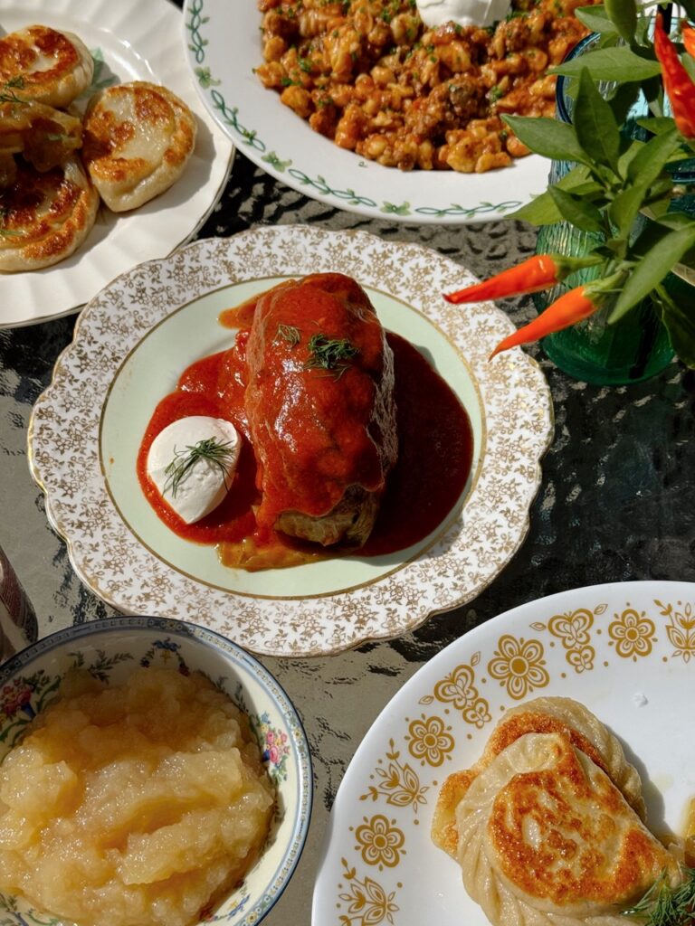 A series of white plates with European food on them in thick sauces. 