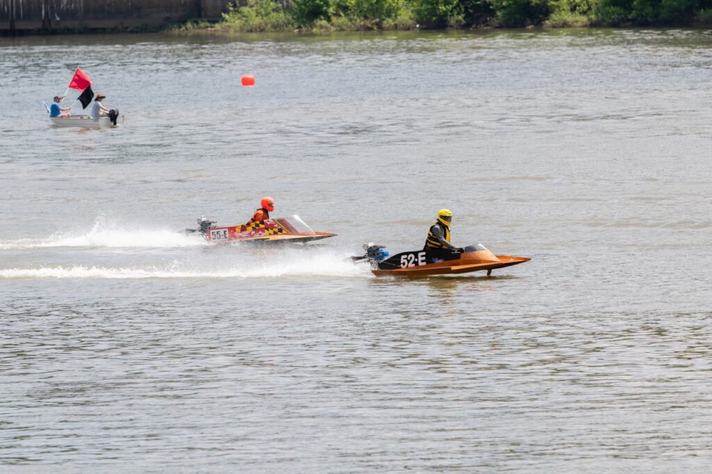 Two regatta boats race on the river. 