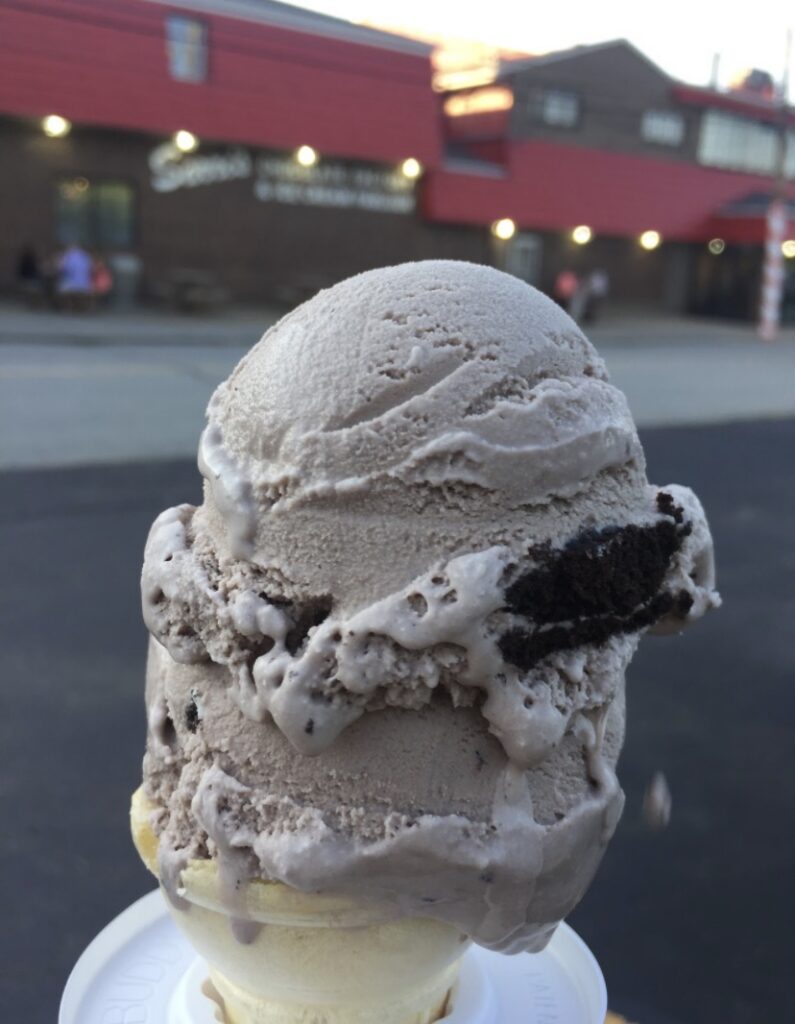 A scoop of cookies and cream ice cream in a cake cone.