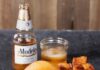 A Local’s Favorite Spots to Grab a Burger in Pittsburgh A burger with plenty of veggies on a balck plate with a stack of potatoes beside it and a beer behind it.