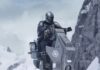 After 7 Years, ‘Star Wars’ Returns to Cinemas With ‘The Mandalorian and Grogu’ The Mandalorian rides a Star Wars bot walker in the snow and mountains.