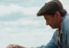 Collier’s Cuts: There’s Trouble Ahoof for ‘The Sheep Detectives’ High Jackman in a cap kneels down to pet a brown sheep.