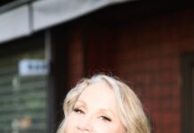 Three Rivers Arts Festival Announces Music Headliners and Performances Joan Osborne with long blonde hair in front of a building.