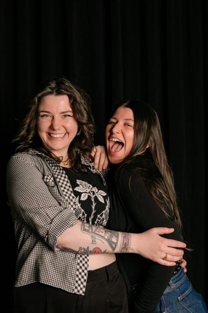 Two women hug and laugh.