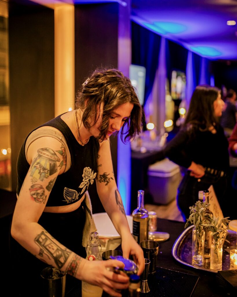 A woman adds the final touch to a cocktail glass.