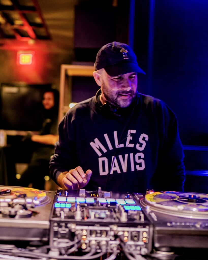 A DJ works behind the soundboard.