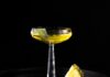 Sage Advice: A Sage-Infused Gin Cocktail A tall coupe glass with a yellow sage-infused gin cocktail and a slice of pineapple beside the glass.