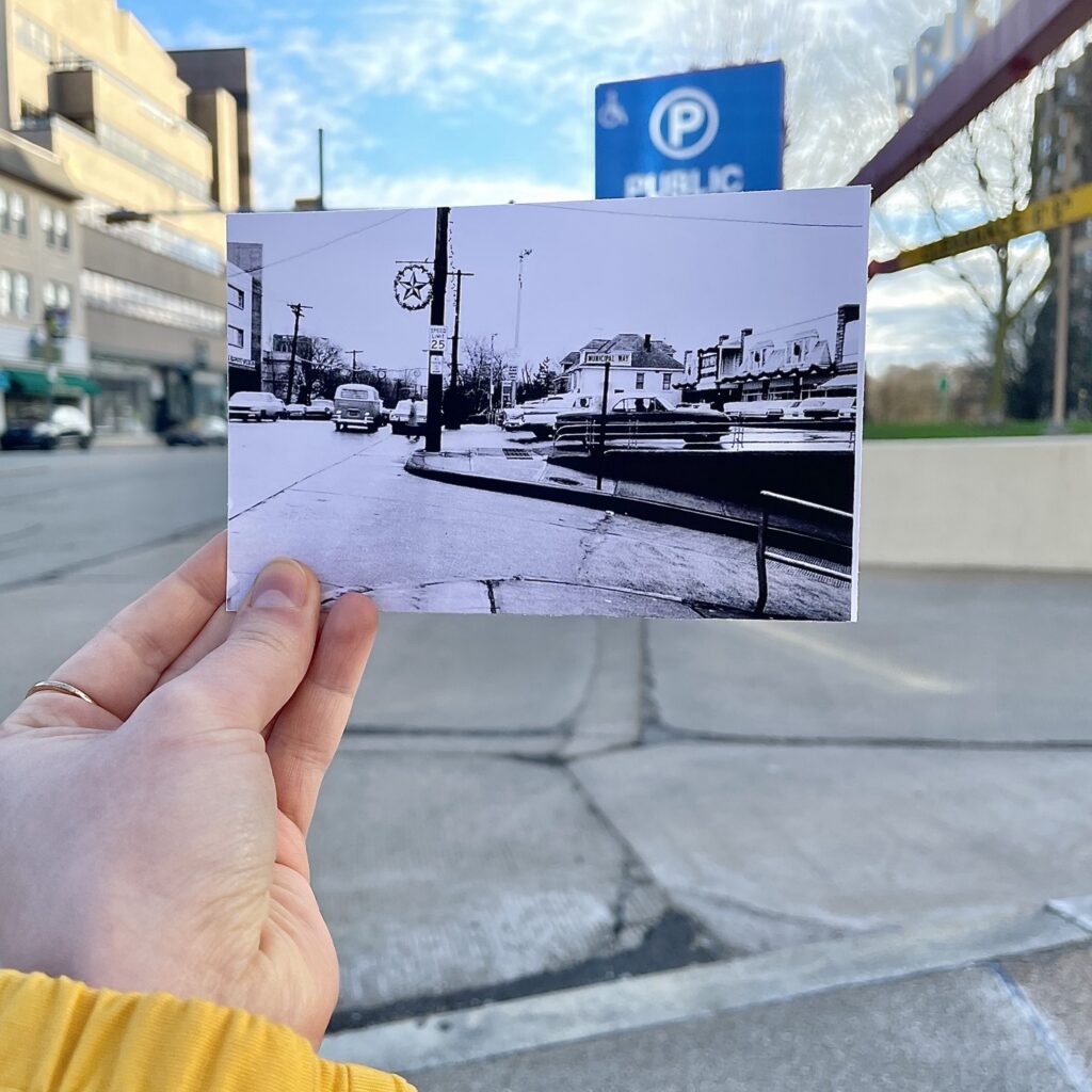 A person holds a black and white photo in front of an intersection in Mt. Lebanon. 