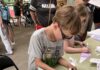 Kick Off Summer Reading Hands-On with Carnegie Library of Pittsburgh A kid colors a paper airplane green at the Carnegie Library.