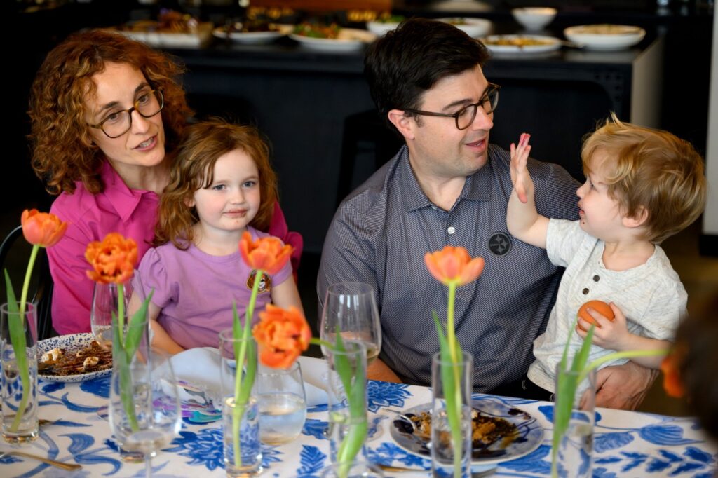 Mayor Corey O'Connor and his wife hold their boy and girl children at the table.