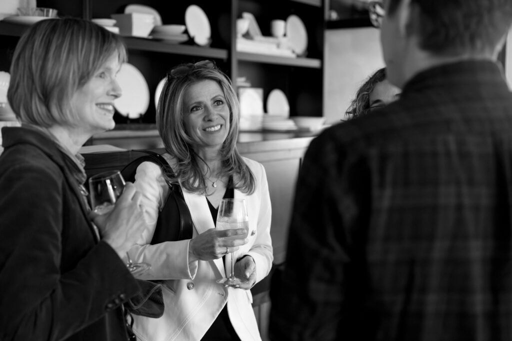 Two women and a man talk together in a group.