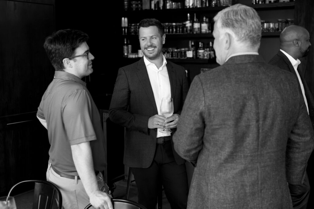 Mayor O'Connor talking to Justin Matase and Keith Recker in suit jackets.