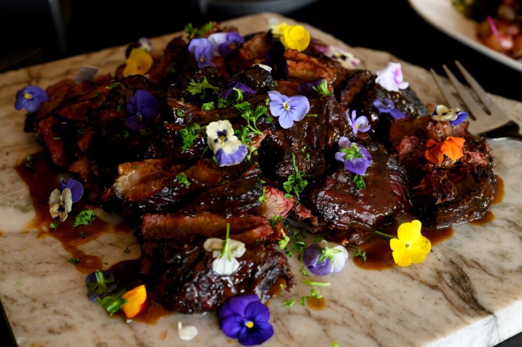 BBQ with edible purple flowers on top.