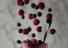 Try These Pittsburgh Milkshake Destinations Blueberrys and raspberries fall into a milkshake glass filled with a white milkshake with the aforementioned berries.