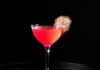 King’s Scale: A Dragon Fruit Cocktail A Nick and Nora glass with a bright magenta dragon fruit cocktail inside with a dehydrated dragon fruit slice garnish.